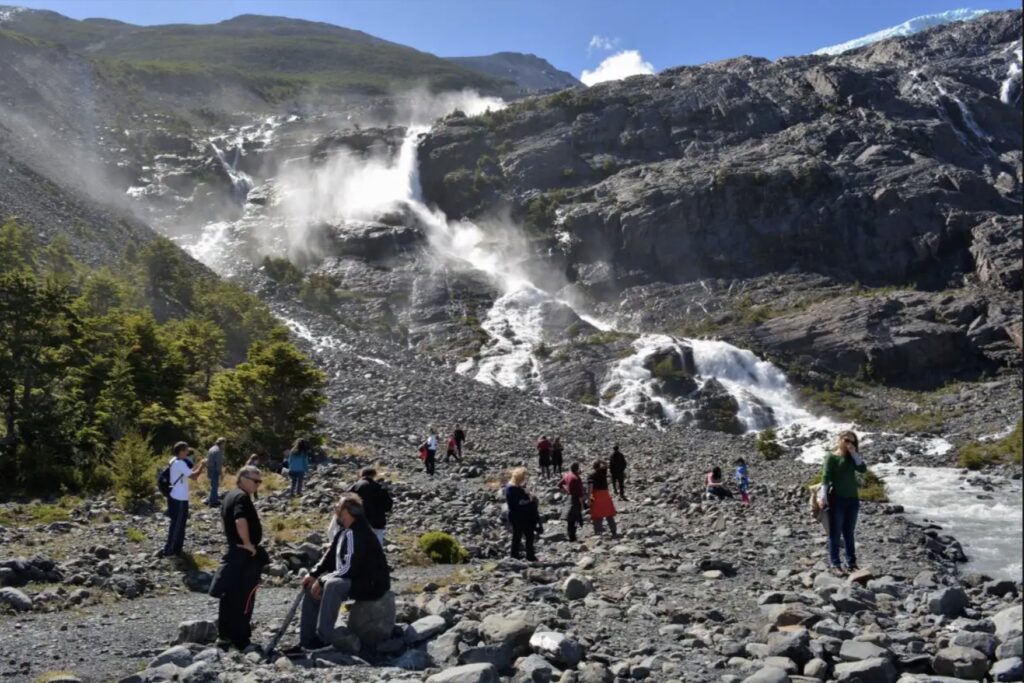 Las cascadas que nacen del Glaciar Negro cayendo por el paredón rocoso, vistas desde el pedregal de la base del Cerro Negro